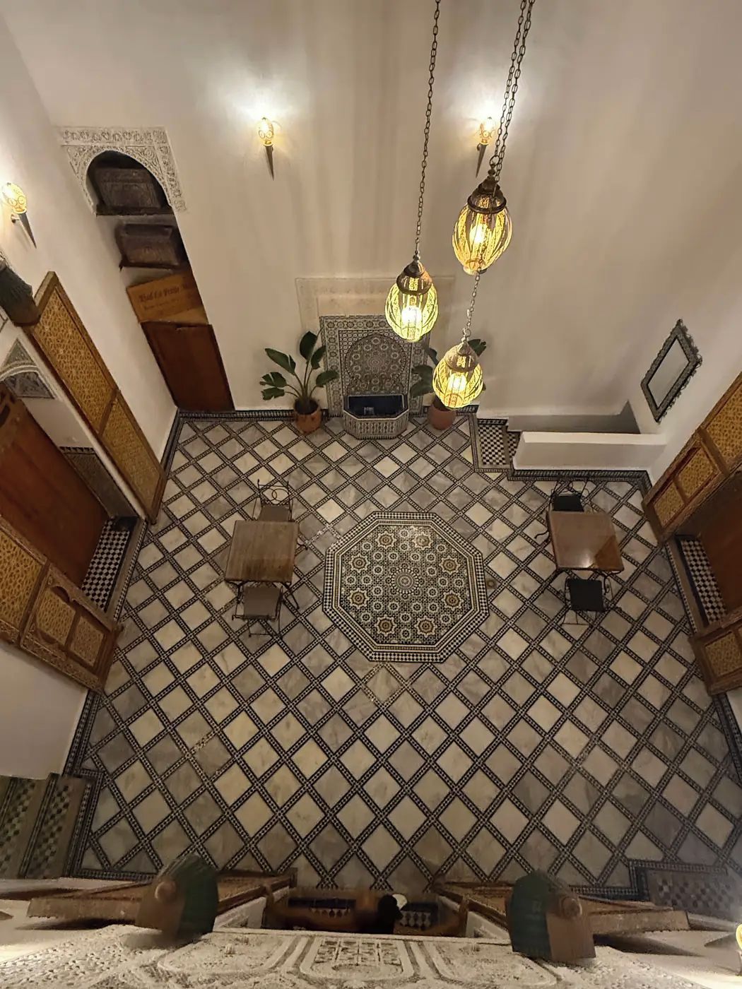 Una habitación con piso estampado, lámparas colgantes y un elemento decorativo central.