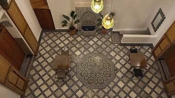 Una habitación con piso estampado, lámparas colgantes y un elemento decorativo central.