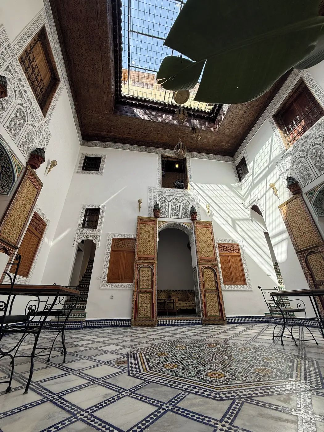 Un interior con suelo de baldosas, un arco central y paredes con diseños.