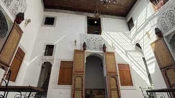 Un interior con suelo de baldosas, un arco central y paredes con diseños.