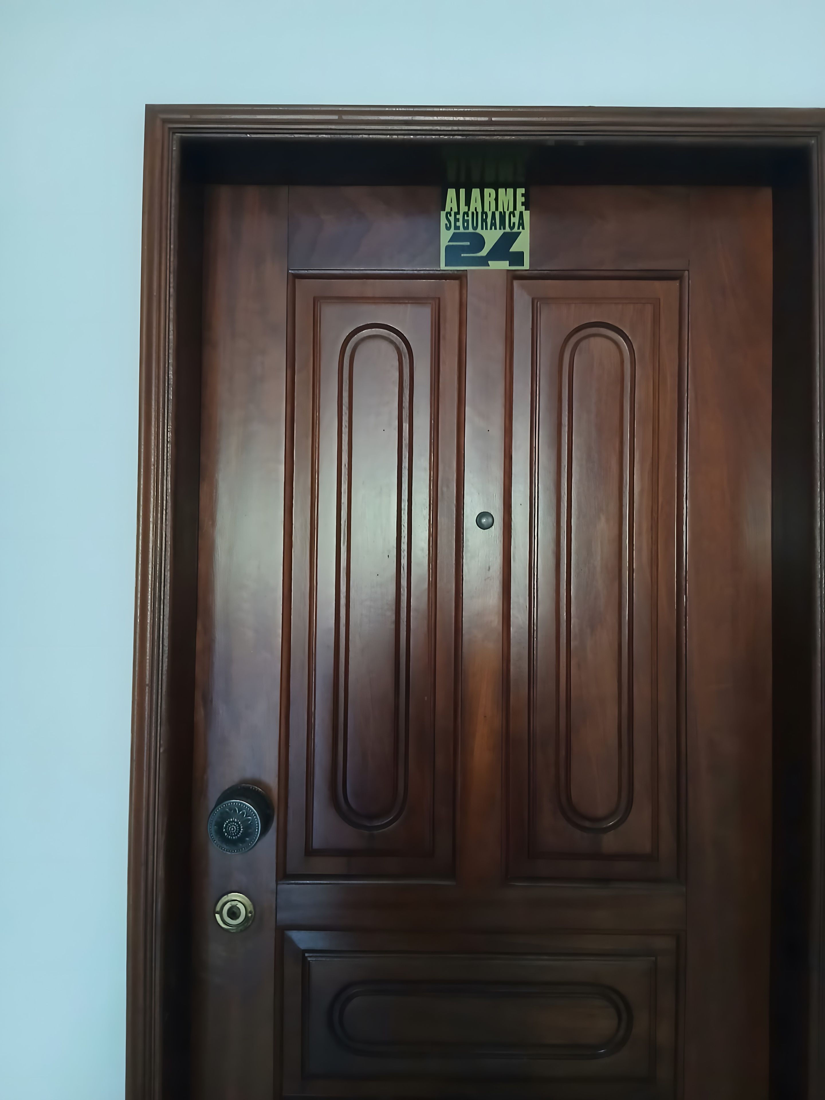 Una puerta de madera con pomo y cerradura de latón.