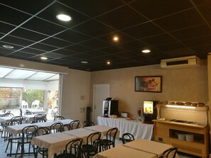 A restaurant with tables and chairs, a food display, and a ceiling with recessed lighting. - 10 min du centre ! Chambre Triple + Accès Piscine (Aix En Provence)