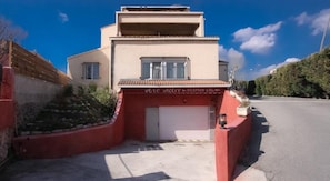Un bâtiment à deux étages dont l’entrée, qui sert de réception, est indiquée par le panneau « Arc Hotel ».