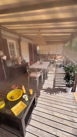 An outdoor patio with a dining table, chairs, and a hanging light fixture. - Stunning, fully equipped mobile home in a very quiet community (Sainte-Maxime)