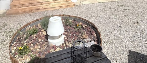 Un espacio de estar al aire libre con techo, una mesa y una maceta en primer plano.