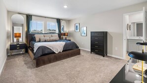 Un dormitorio con cama, mesitas de noche, cómoda y espejo.