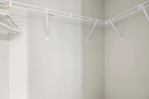 Un tendedero metálico blanco en un rincón de una habitación con paredes lisas.