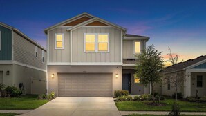 A two-story residential house with a garage, a driveway, and a well-maintained lawn. - NEW - Cozy & Spacious 4bedroom Retreat! (Wesley Chapel)