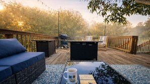 A deck with outdoor furniture, a grill, and a book. - Charming Home Near Macdill AFB Hot Tub Fire Pit (Tampa)