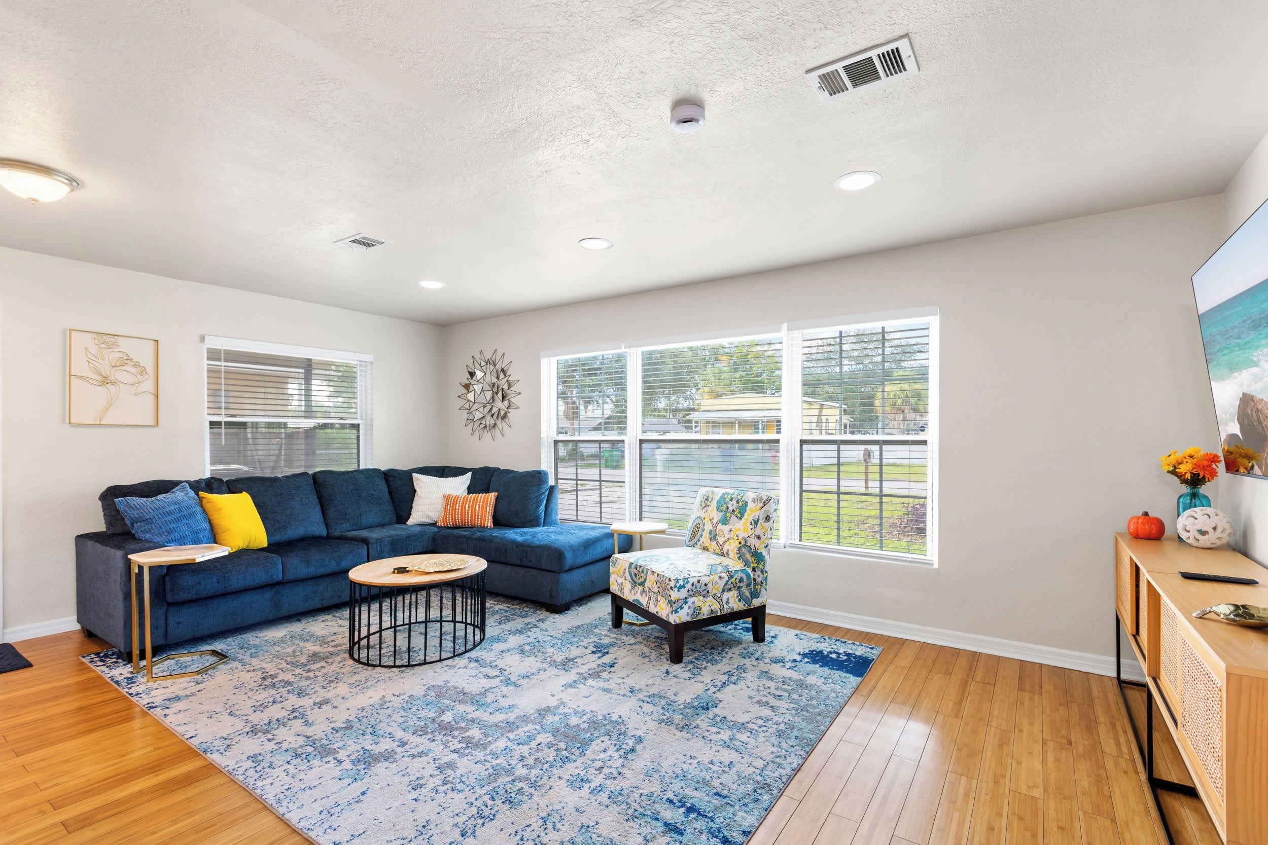 A modern living room with a sectional sofa, a round coffee table, and a patterned rug.