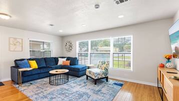 A modern living room with a sectional sofa, a round coffee table, and a patterned rug.