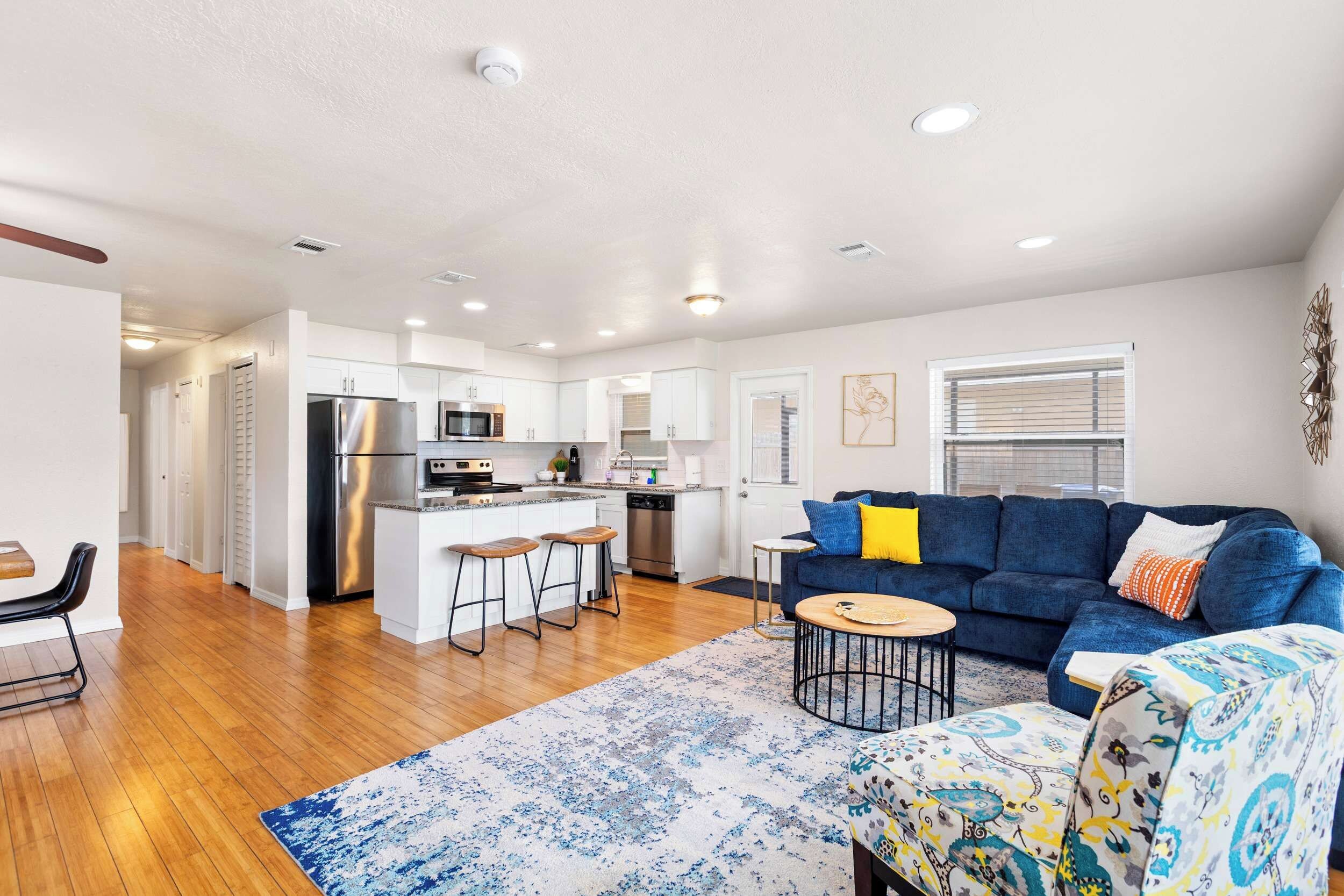 A modern apartment with a kitchen, dining area, and living room.