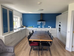 Eine moderne Küche mit einer zentralen Kochinsel, weißen Schränken und einer blauen Akzentwand.