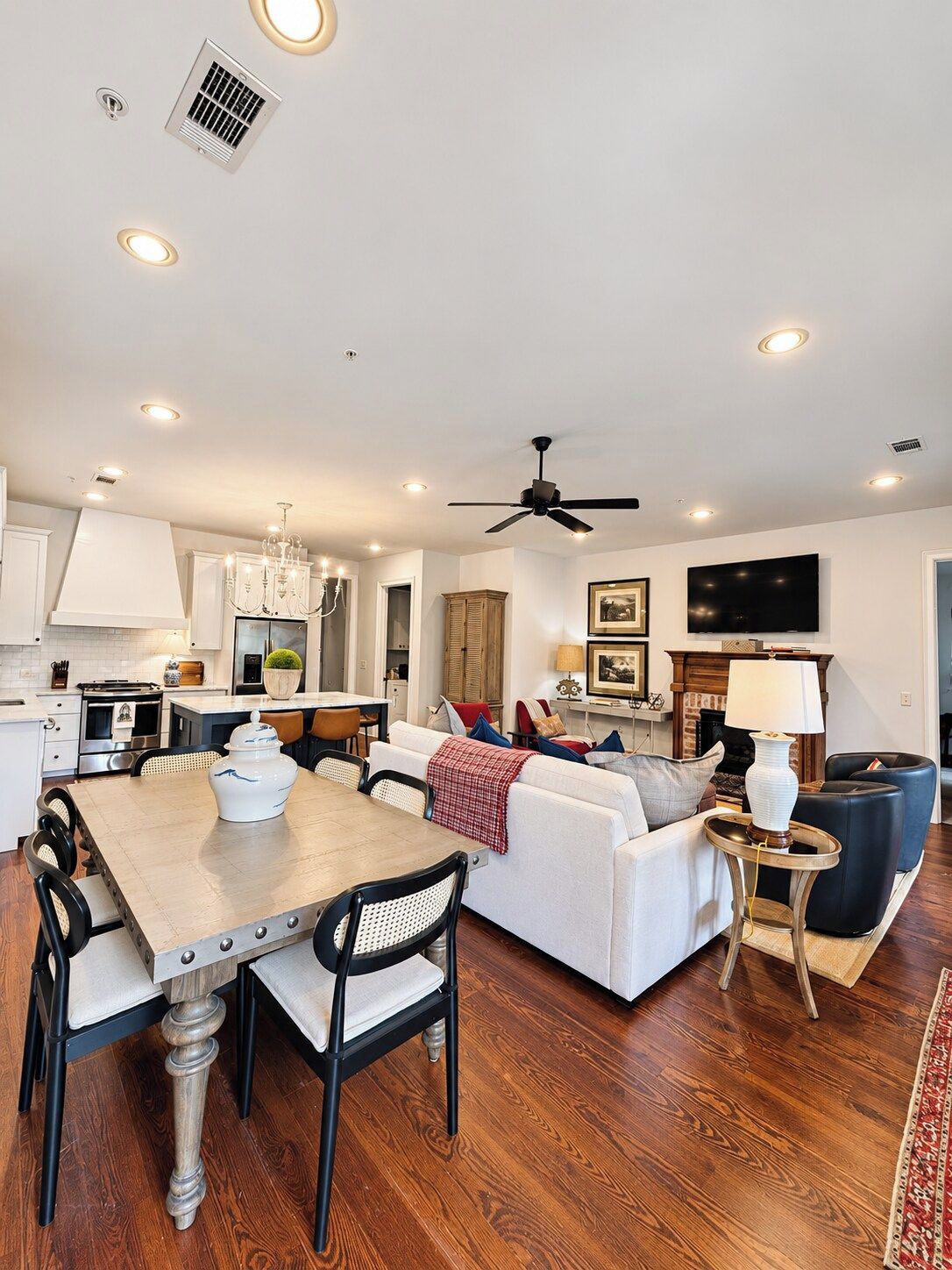 A modern living space with a dining area, kitchen, and seating area.
