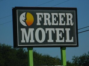 A sign for a motel with a partial moon and sun graphic.