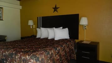 A hotel room with a bed, two bedside tables, a star decoration on the wall, and a lamp on each table.