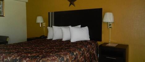 A hotel room with a bed, two bedside tables, a star decoration on the wall, and a lamp on each table.