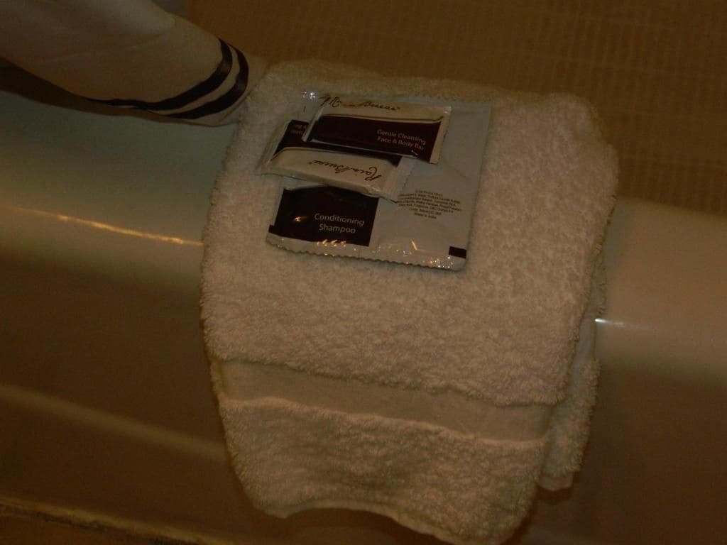 A white towel with two toiletries on it, placed on a surface.