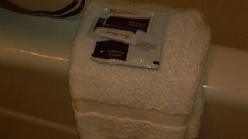A white towel with two toiletries on it, placed on a surface.