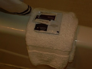 A white towel with two toiletries on it, placed on a surface.