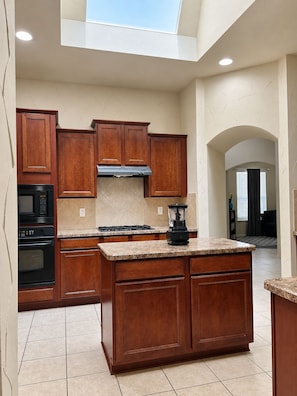 A kitchen with wooden cabinets, a built-in microwave, and a gas stove. - Spacious 4-bedroom house in cool Cedar Hill with AC (Cedar Hill)
