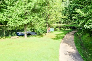 Un parc avec un sentier dallé, des bancs et un panneau d’information.