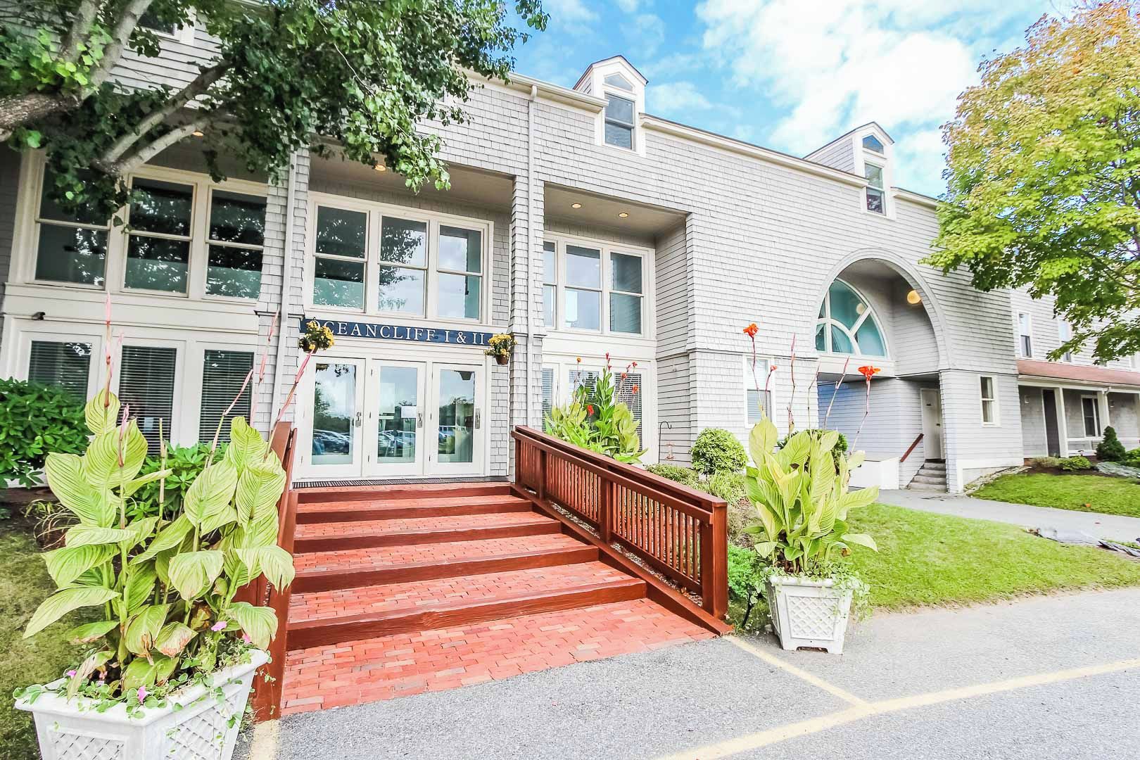 A two-story building with a brick facade, a wooden staircase leading to the entrance, and a sign above the doors.