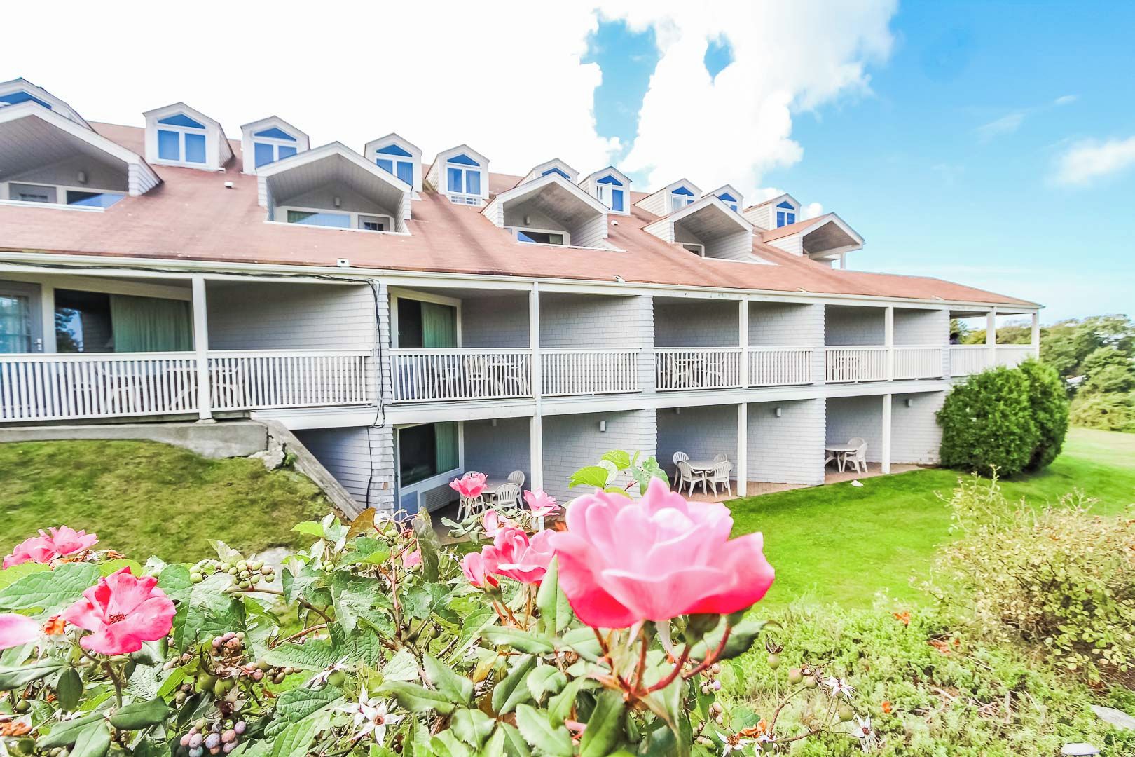 A multi-story hotel with balconies and a well-maintained lawn.