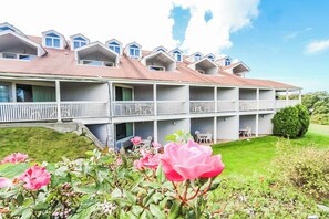 A multi-story hotel with balconies and a well-maintained lawn.