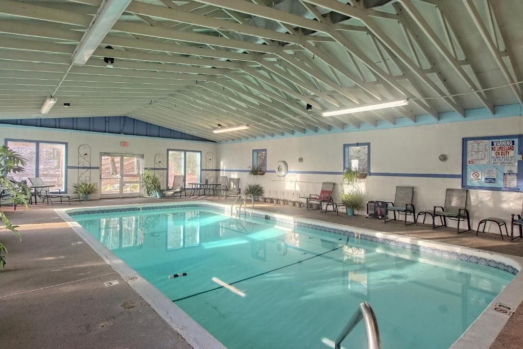 Une piscine intérieure avec des couloirs clairement délimités, des chaises longues et une signalisation de sécurité.