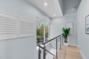 A modern interior with a staircase, a potted plant, and a framed picture on the wall. - Gulfstream Paradise Open Water on the Gulf  6 bed 4 bath with pool, 4 kayaks, and dockage (Marathon)