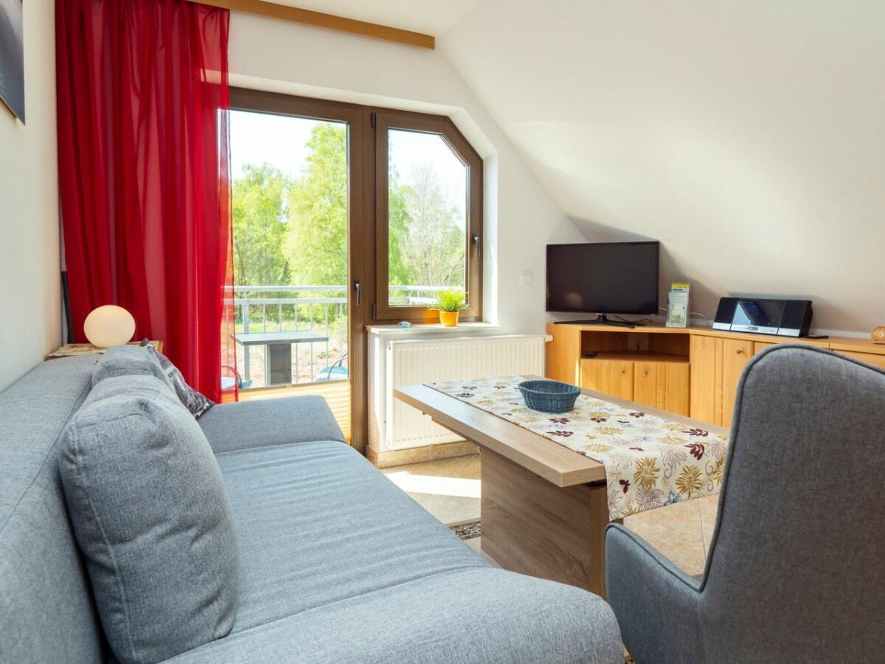 A modern living room with a sofa, a dining table, and a television.