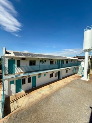 A two-story building with a flat roof, a balcony on the upper floor, and a water tank on the right. - Constanza City Stay (Bonito)