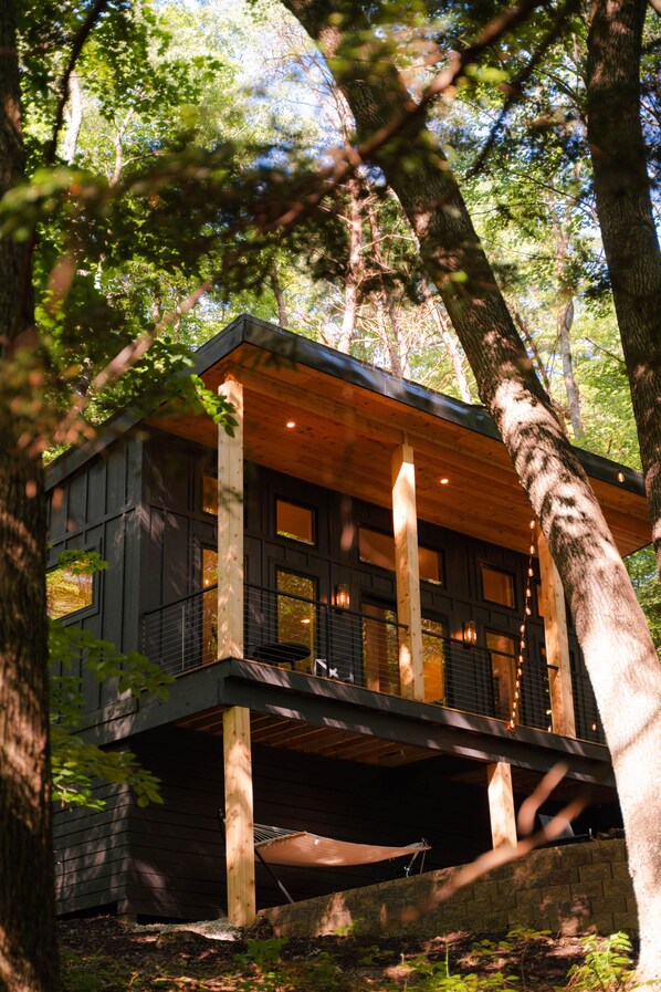A wooden cabin with a balcony, surrounded by trees. - The Pine at Dunlap Ridge (Laurel Township)