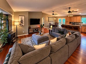 A modern living room with a sectional sofa, a flat-screen TV, and a fireplace. - Summitview Chalet - Mountain Views & CO Charm (Woodland Park)