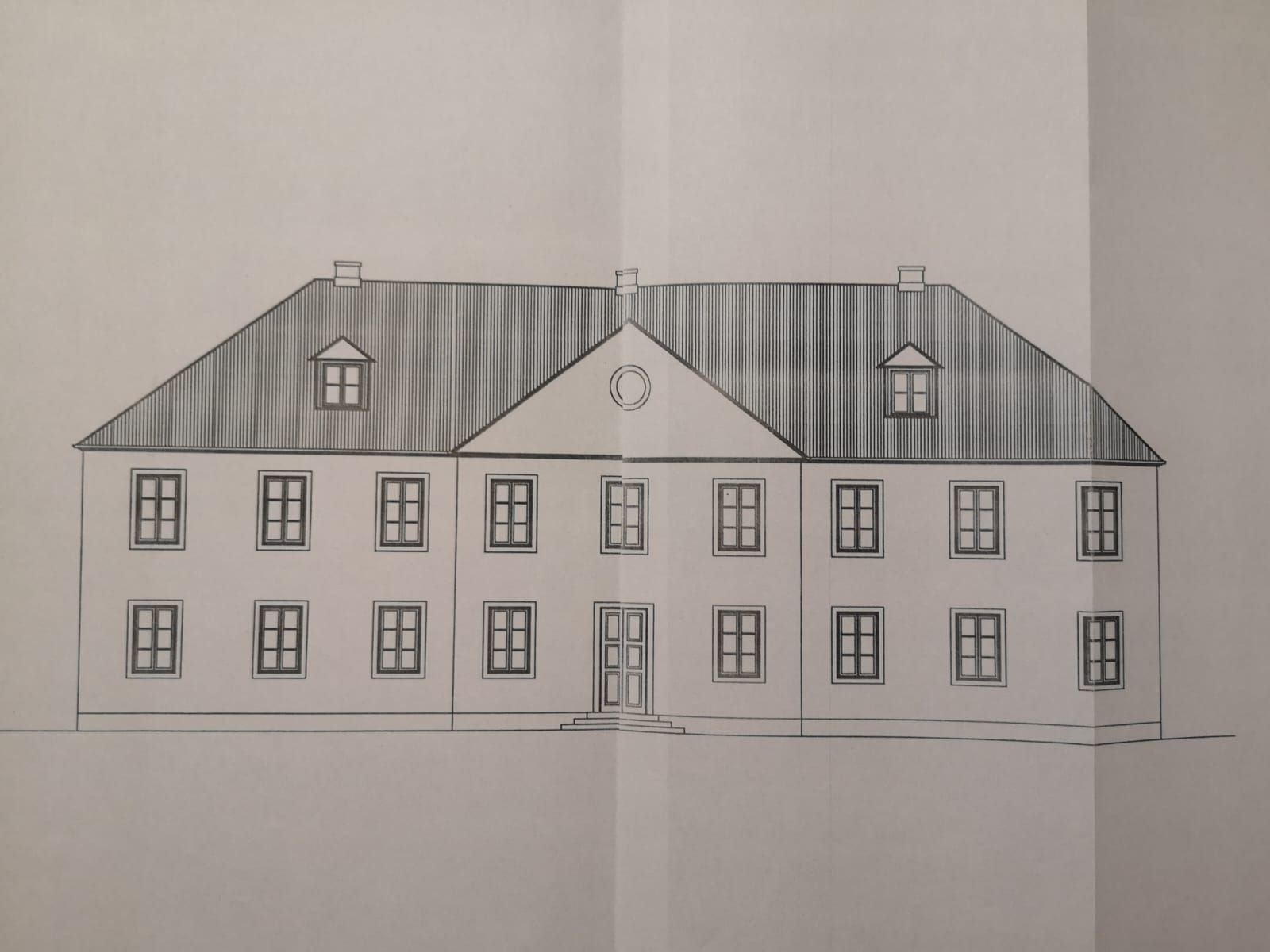 Un bâtiment à deux étages, doté d’une façade symétrique, de nombreuses fenêtres et d’une entrée centrale.