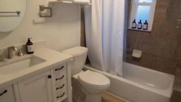 Un baño con inodoro, lavamanos y bañera.