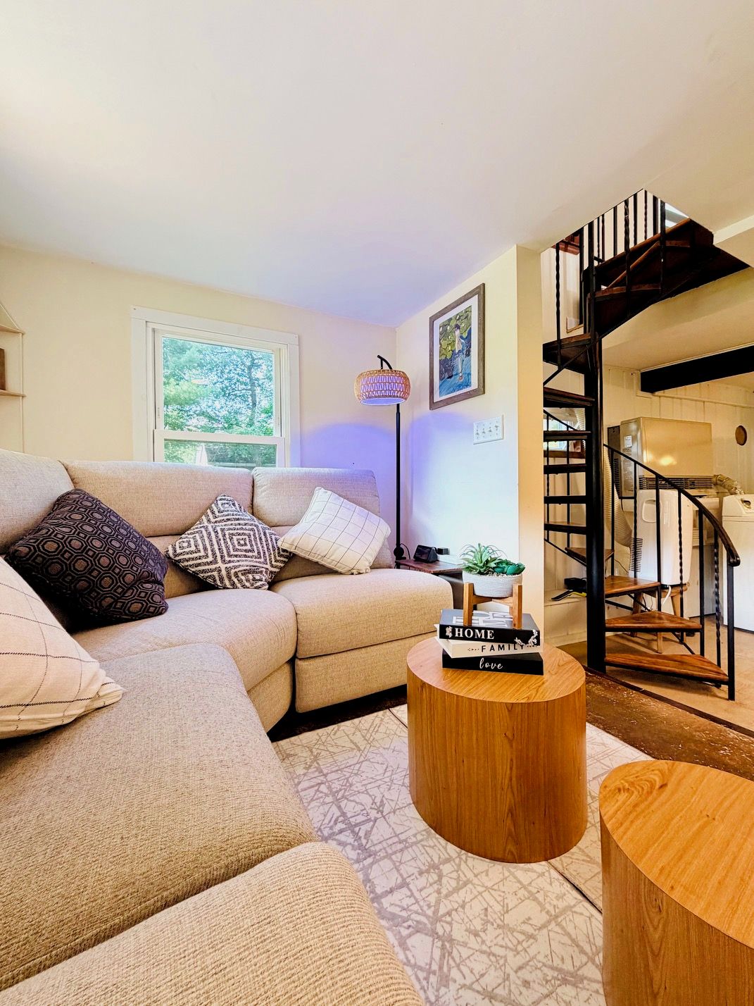 A living room with a sofa, a coffee table, and a staircase.