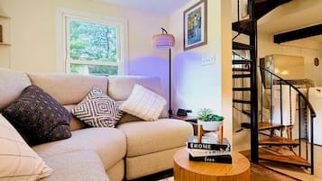 A living room with a sofa, a coffee table, and a staircase.