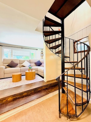 Una sala de estar moderna con una escalera curva.