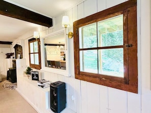 Una habitación con un ventanal grande, una puerta de madera y una pared blanca con un cartel de bienvenida.