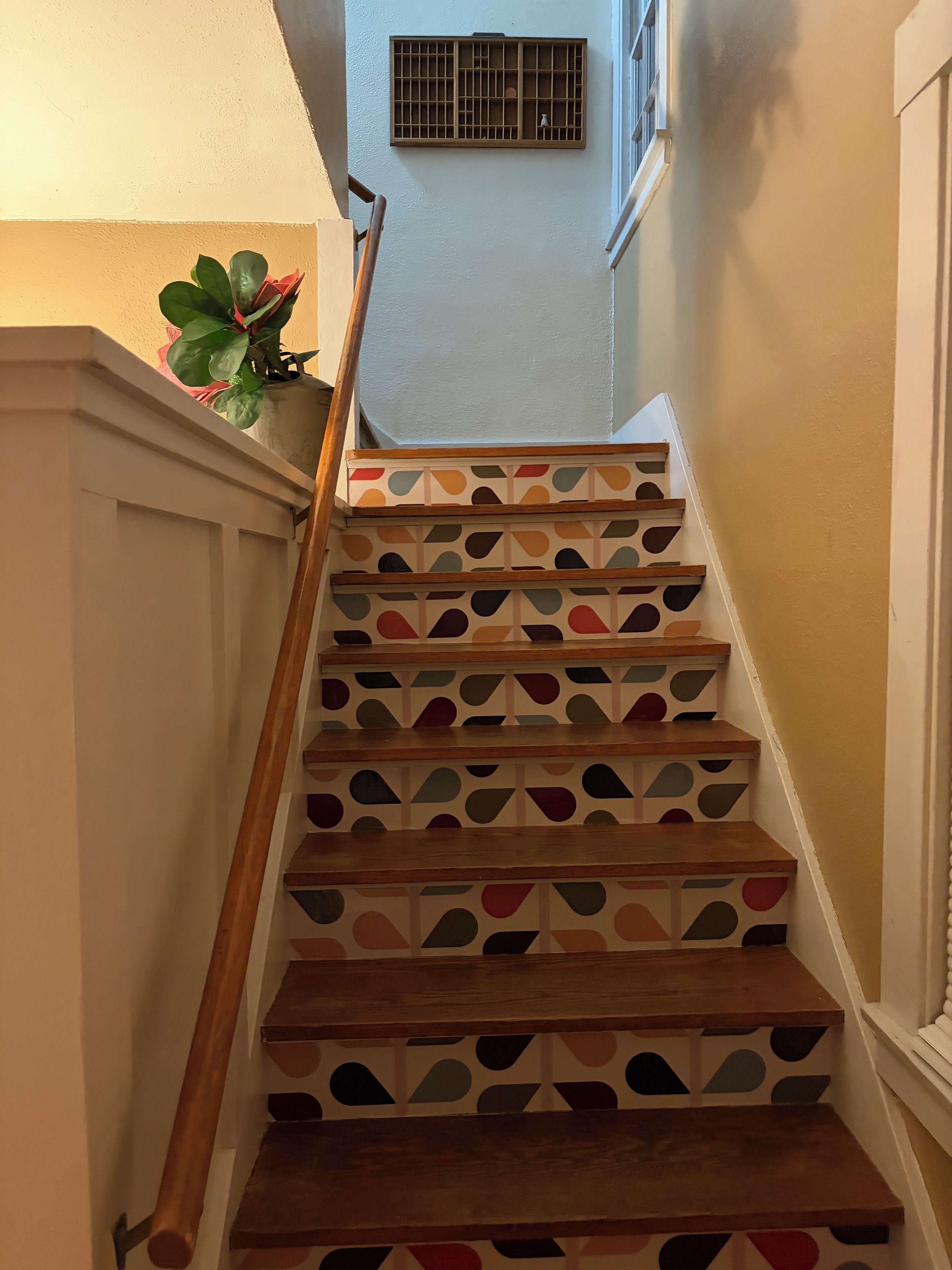 Un escalier avec des marches en bois et un motif géométrique sur les contremarches.
