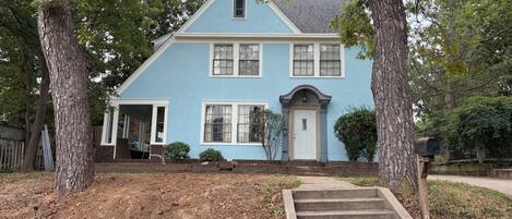 A two-story house with a front porch, a mailbox, and a well-maintained lawn.