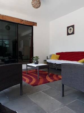 A modern living room with a sofa, a table, and a red rug.
