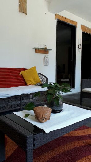 A room with a sofa, a table with a plant, and a door.