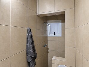 A bathroom with a shower, a towel rack, and a toilet. - Cozy loft-style apartment near downtown Oaxaca (Oaxaca de Juárez)