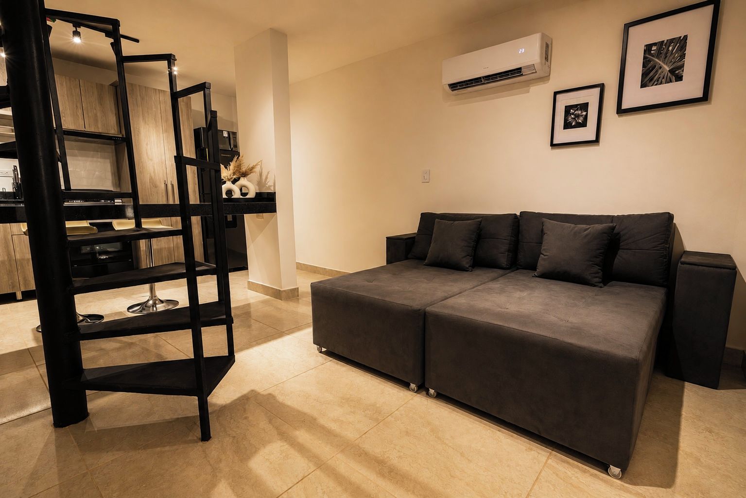 Un salon moderne avec un canapé, une étagère noire et un appareil de climatisation.