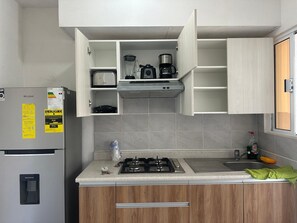 Cozinha equipada com geladeira, fogão, pia e armários.