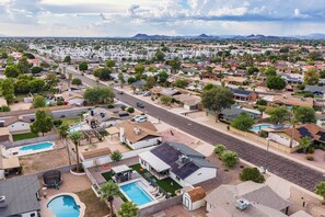 A residential area with multiple houses, a main road, and a large swimming pool. - Modern Paradise Retreat Pool & Outdoor Dining (Phoenix)