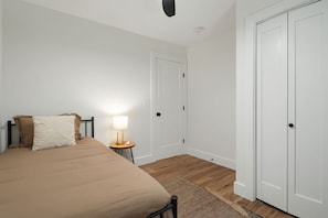 A bedroom with a bed, bedside lamp, and two white doors. - Close to Blue Ridge Parkway, Mtn Views, Firepit (Asheville)